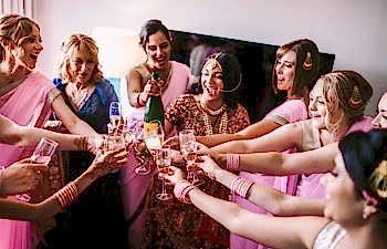 Bridal Shower Games - a bride and her party hold their glasses together.