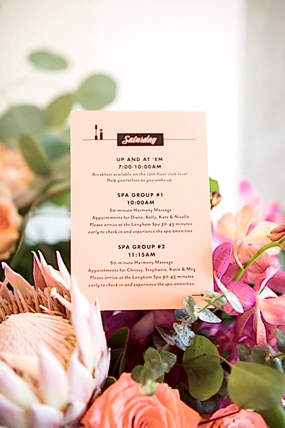 Bachelorette spa itinerary printed on peachy pink paper, among a bright flower arrangement