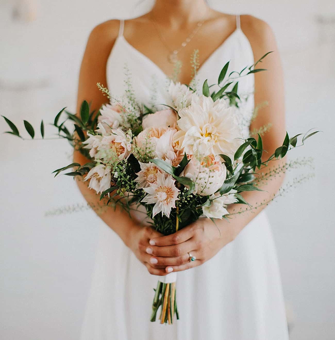hand-tied bridal bouquet with pale peach flowers and greenery