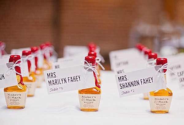 Close up of small single use Maker's Mark bottles with names attached as table assignments