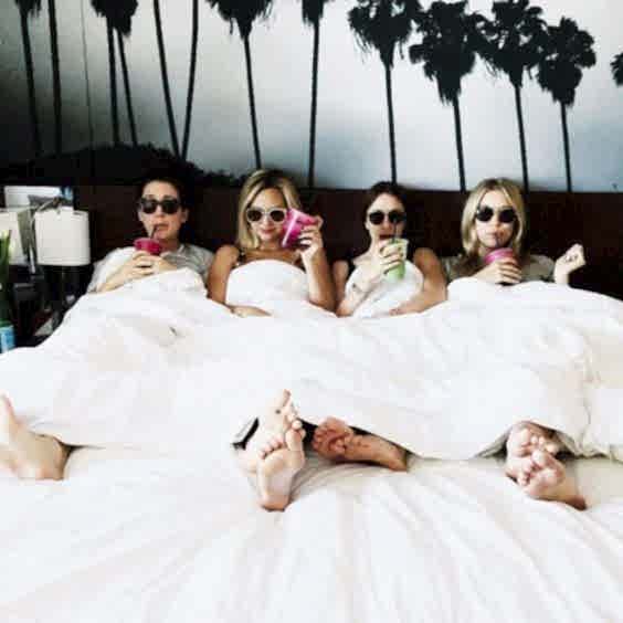 bachelorette party - Four women in a bed with drinks