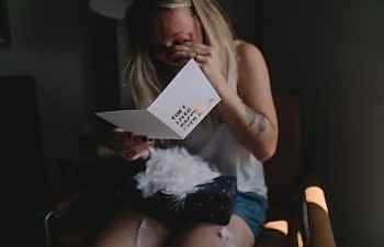 A woman reads a card, and cries