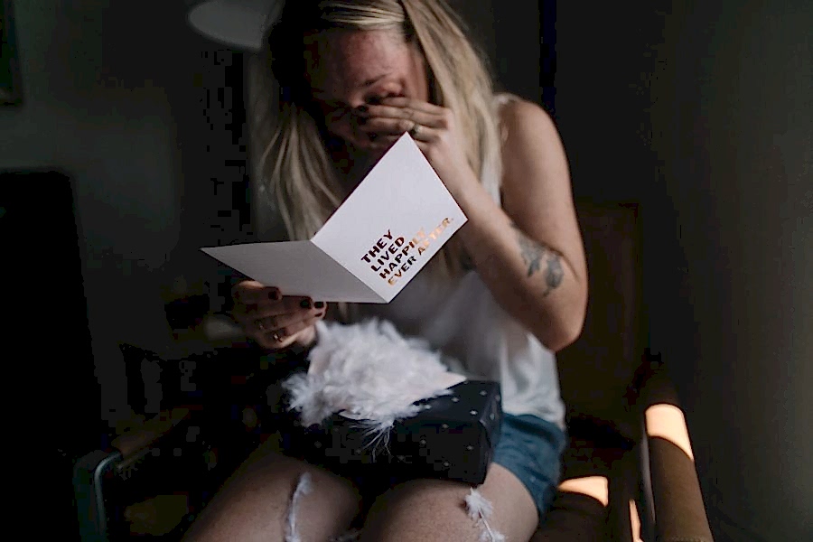 A woman reads a card, and cries