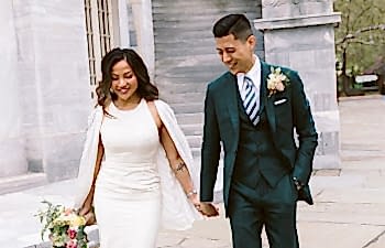 A bride and groom walk hand in hand