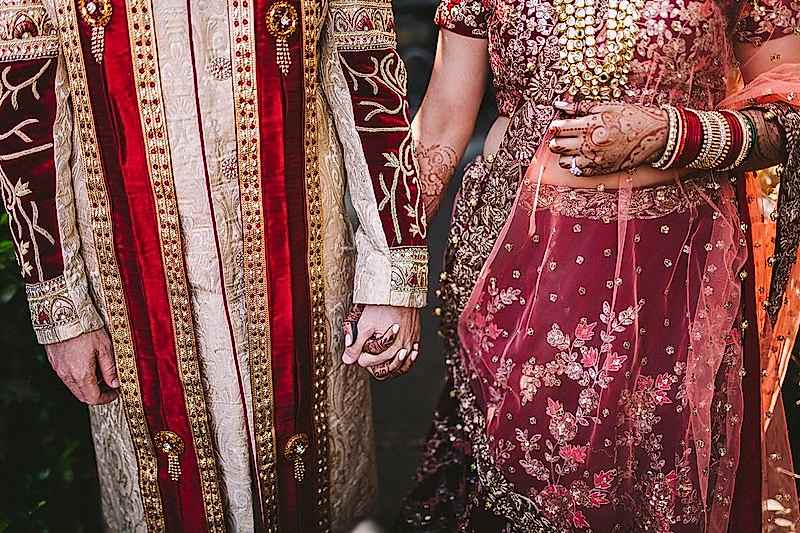 Indian bridal couple holding hands