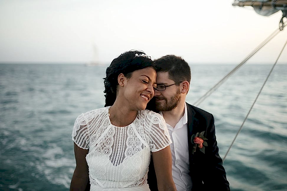 Two people cuddle together while sitting on a boat
