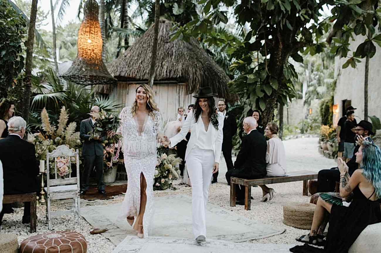 Two women walk together, at the beach.