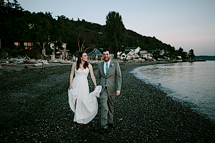 A couple walk along the beach.