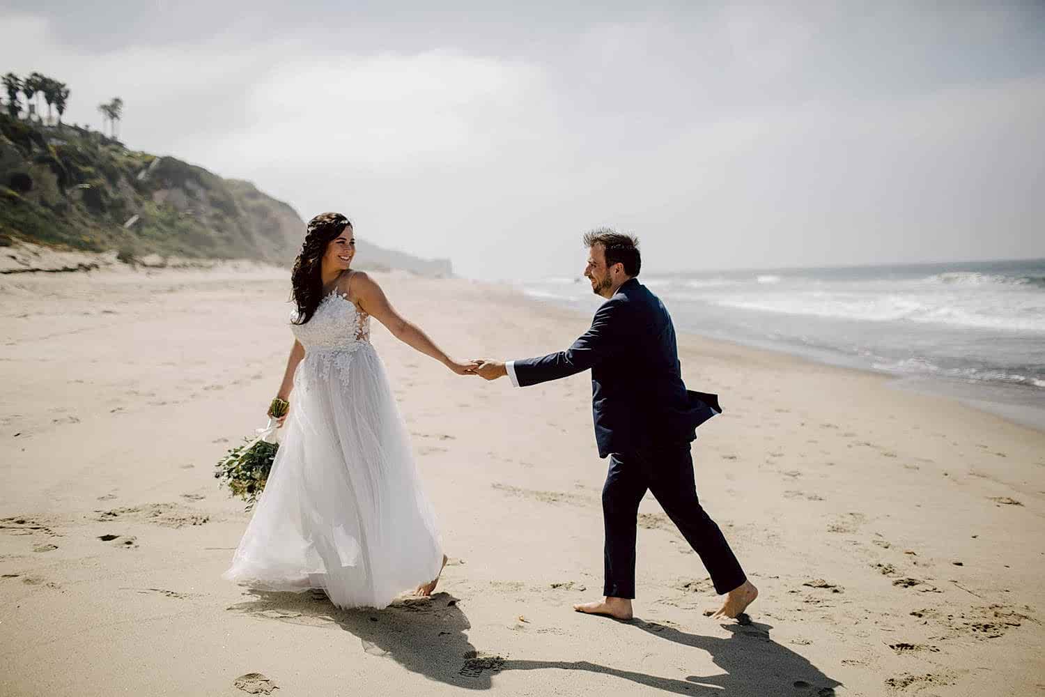 A couple walk together, at the beach.