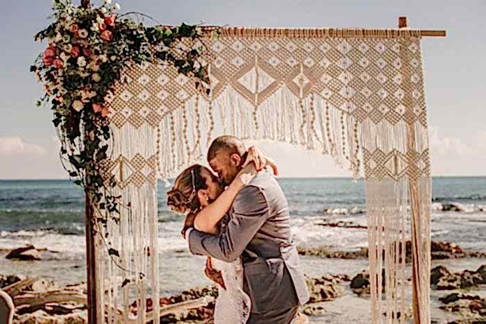 Two people kiss while at the beach.