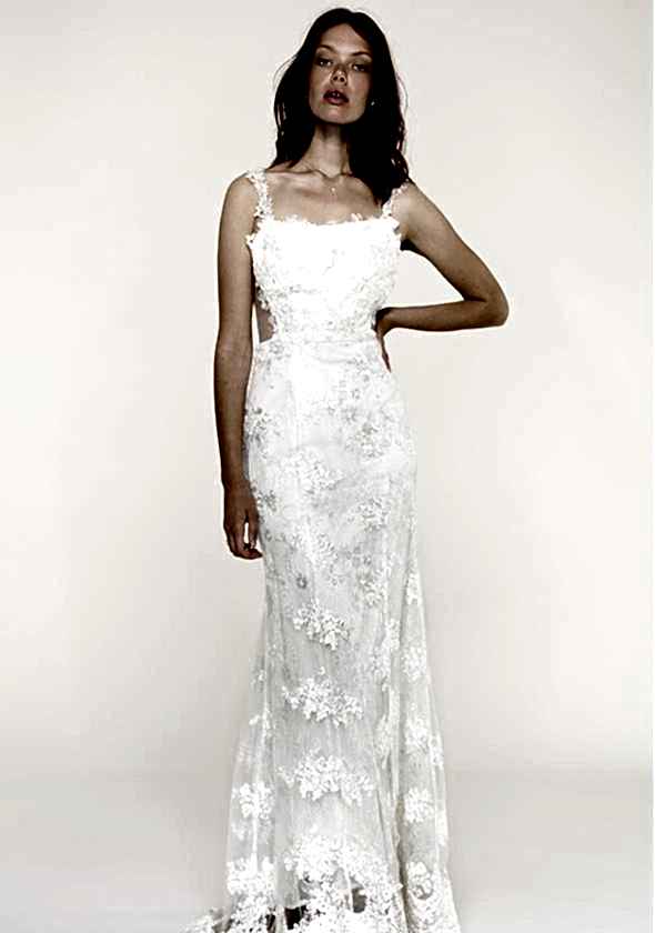 A woman wears a white dress with an embroidered sheer overlay