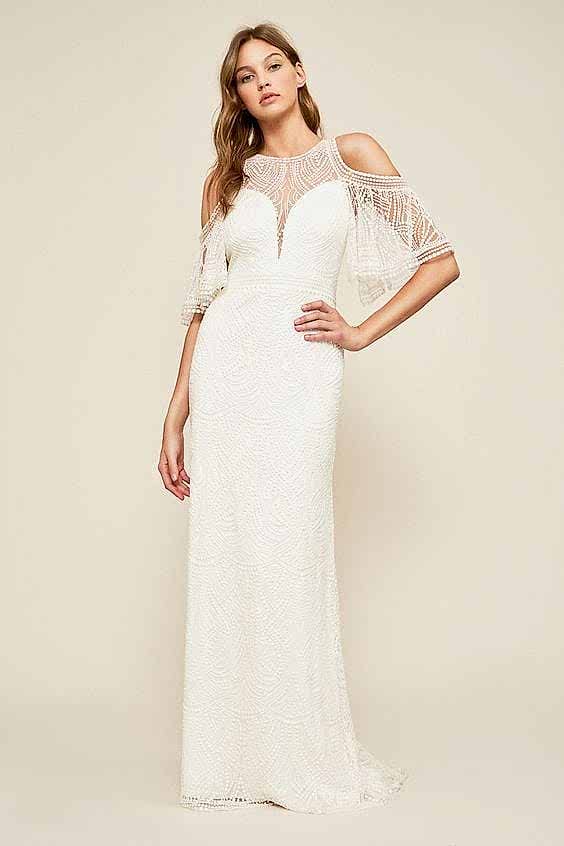 A woman wears a white dress with lace cold-shoulder elbow-length bell sleeves