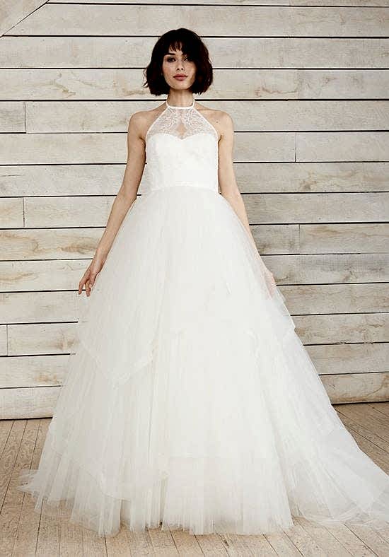 A woman wears a white dress with a high-neck halter and a large tulle skirt