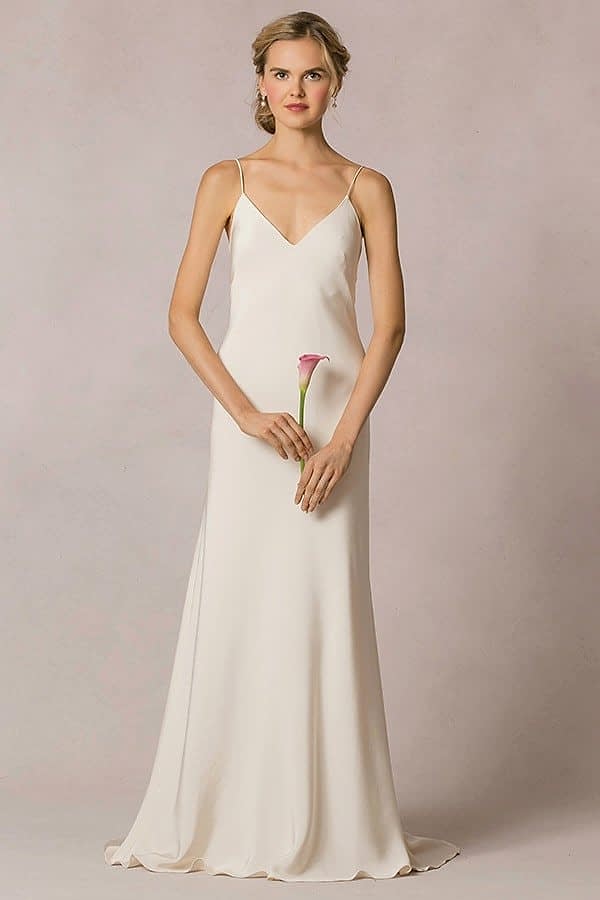 A woman wears a simple white spaghetti strap slip dress