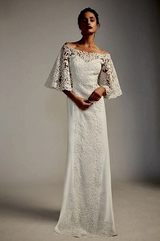 A woman wears an off-the-shoulder white dress with elbow-length bell sleeves