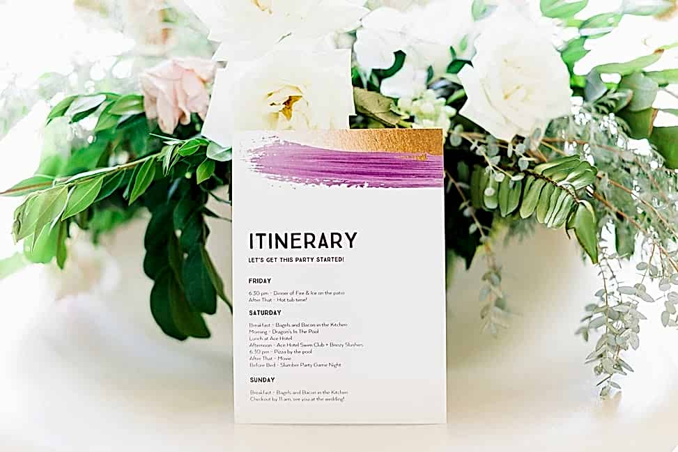 A full color rectangular itinerary in front of a floral arrangement