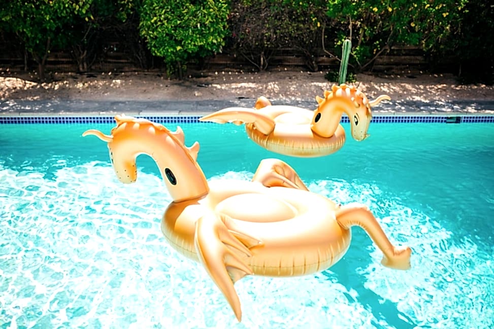 two gold inflatable dragon rafts float in a pool