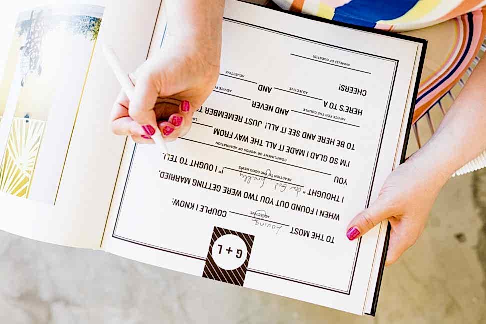 a woman fills in a Mad Libs style prompt in a custom personalized guest book