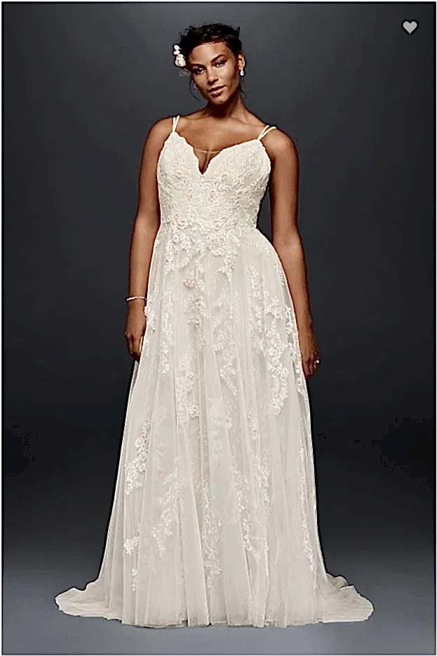 a woman wears an off-white dress with double spaghetti straps and a peek-a-boo neckline with an embroidered sheer overlay with pale pink flowers