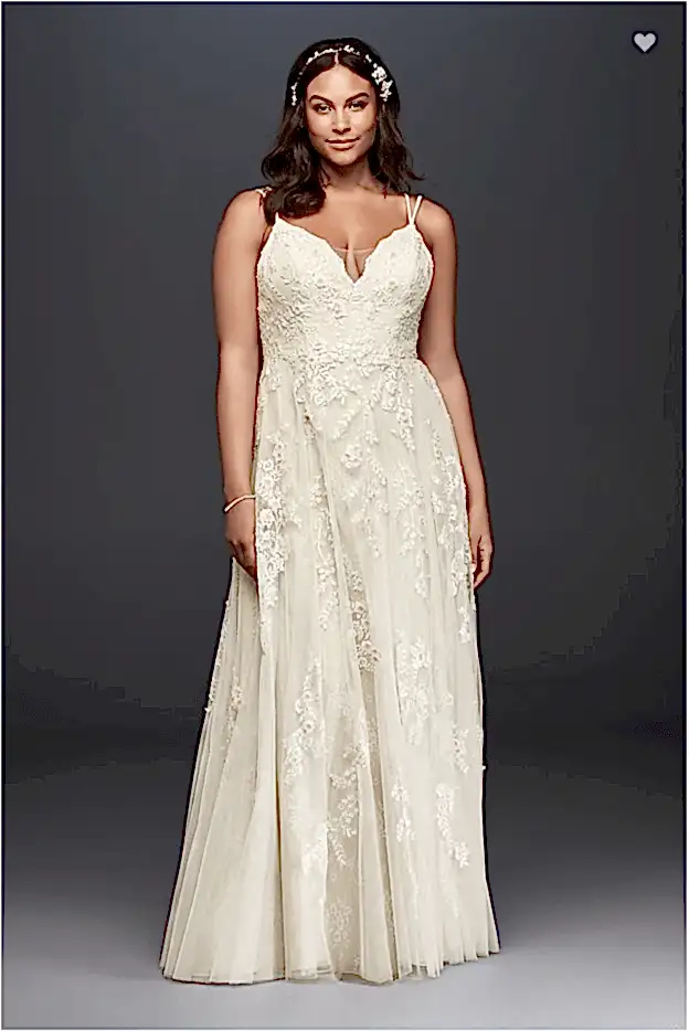 A woman wears an off-white wedding dress with double spaghetti straps and a sheer embroidered flower overlay with a peekaboo v-neck