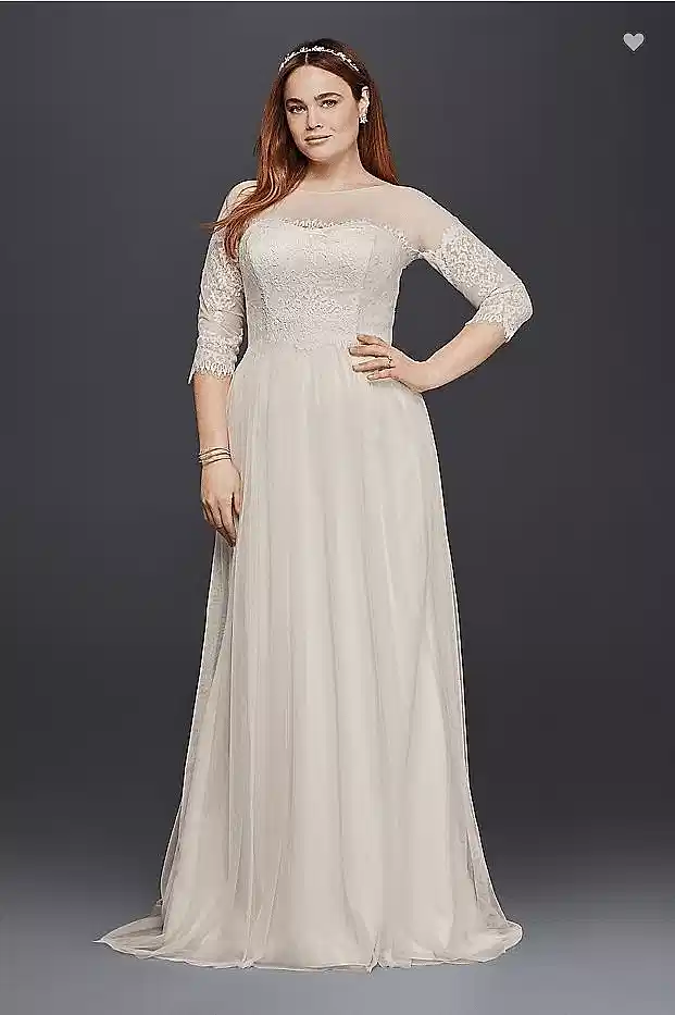 a woman wears an off-white dress with a lace bodice, illusion neckline, and lace "off-the-shoulder" sleeves
