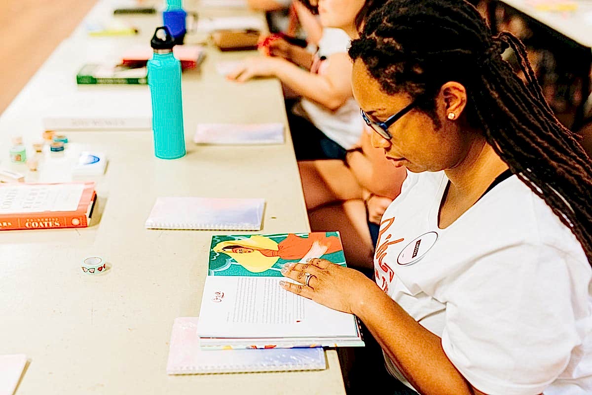 A woman flipping through a book during a journaling workshop let by Rachel Wilkerson at the compact summer camp in la Honda, CA