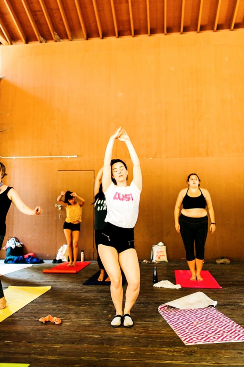 Women doing yoga during Chloe Jackman's workshop at the compact summer camp in la Honda, CA