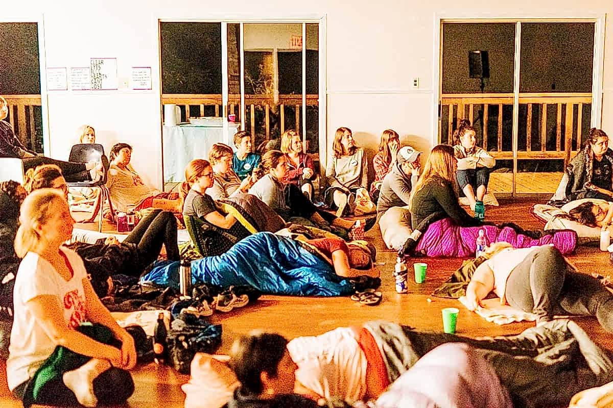 Women lounging on sleeping bags during movie night at the compact summer camp in la Honda, CA