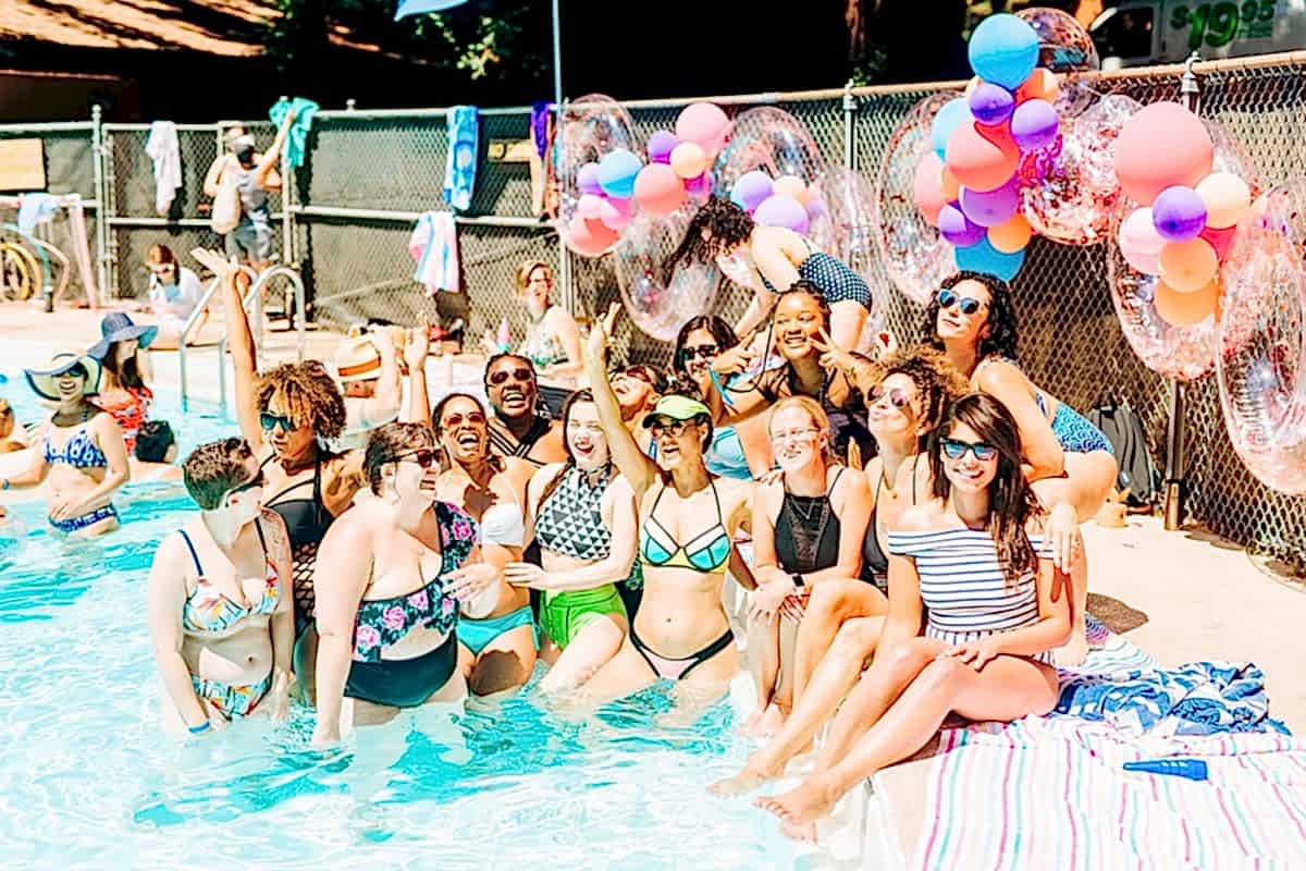 A group of women both in and out of the pool living their best lives at the compact summer camp in la Honda, CA