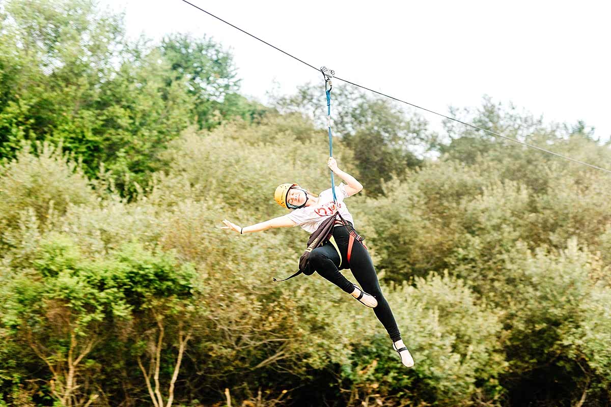 A woman at peace, smiling as she ziplines at the compact summer camp in la Honda, CA