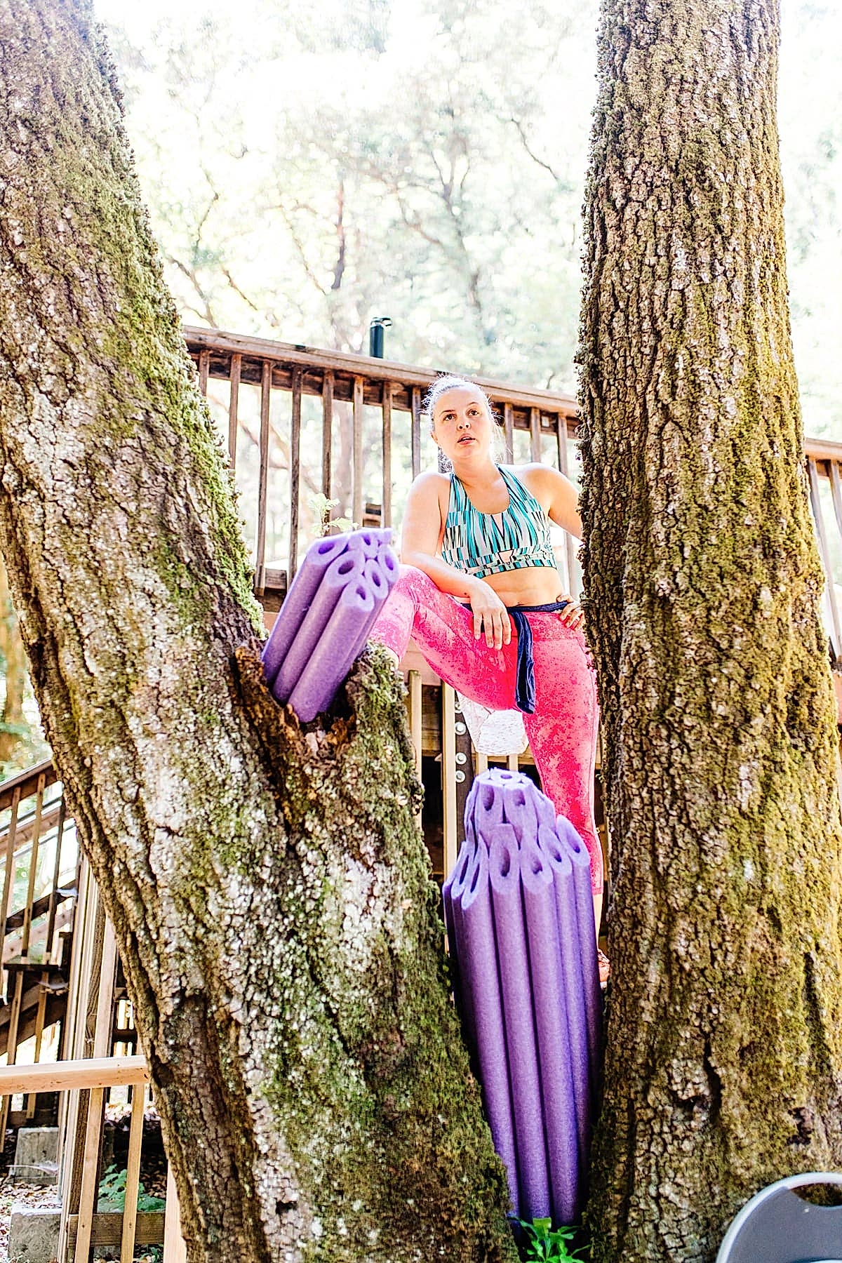 Jess Rutherford resting after getting down to business designing camp near an amethyst crystal pool noodle sculpture in a tree at the compact summer camp in la Honda, CA