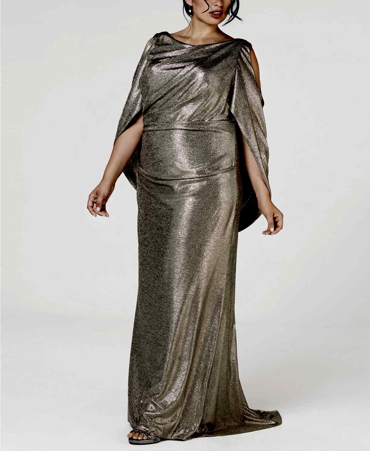 Brunette woman wearing gold gown in white room