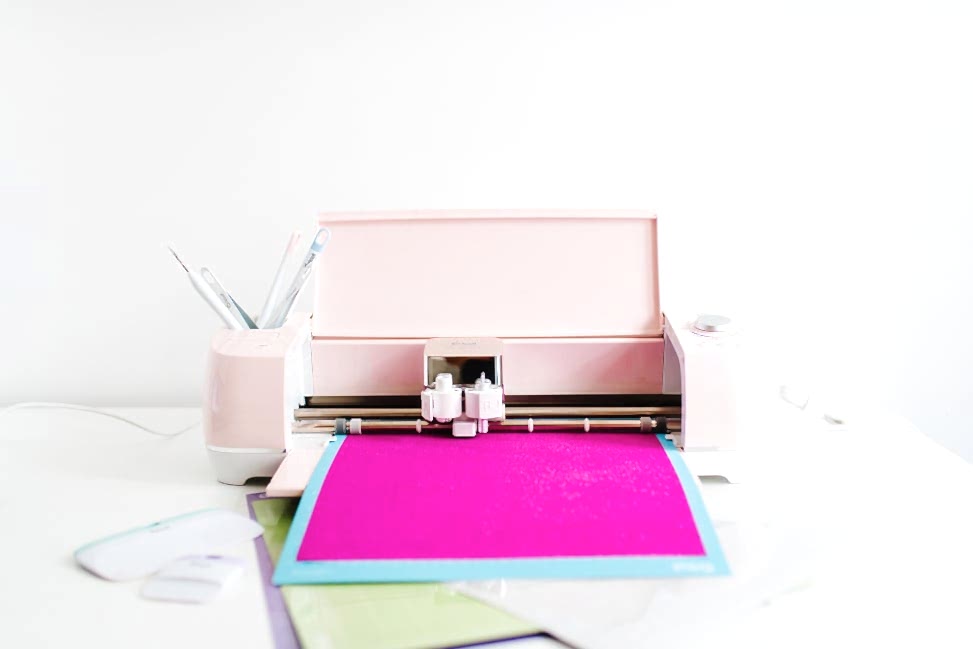 A pink Cricut Explore Air 2 Machine from Michael's Weddings with paper in place