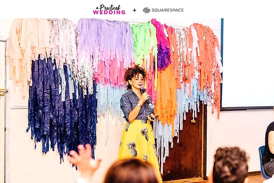 cyndie spiegel leading a keynote at the compact summer camp in front of a colorful fringe backdrop. The text, "A Practical Wedding + Squarespace," reads along the top.