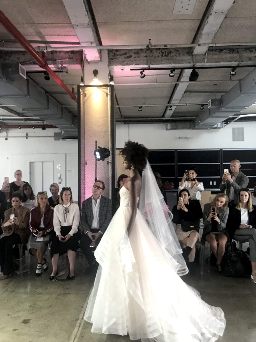 An African-American model walks the runway in a strapless wedding dress with veil in the Watters 2019 fall show at New York Bridal Fashion Week