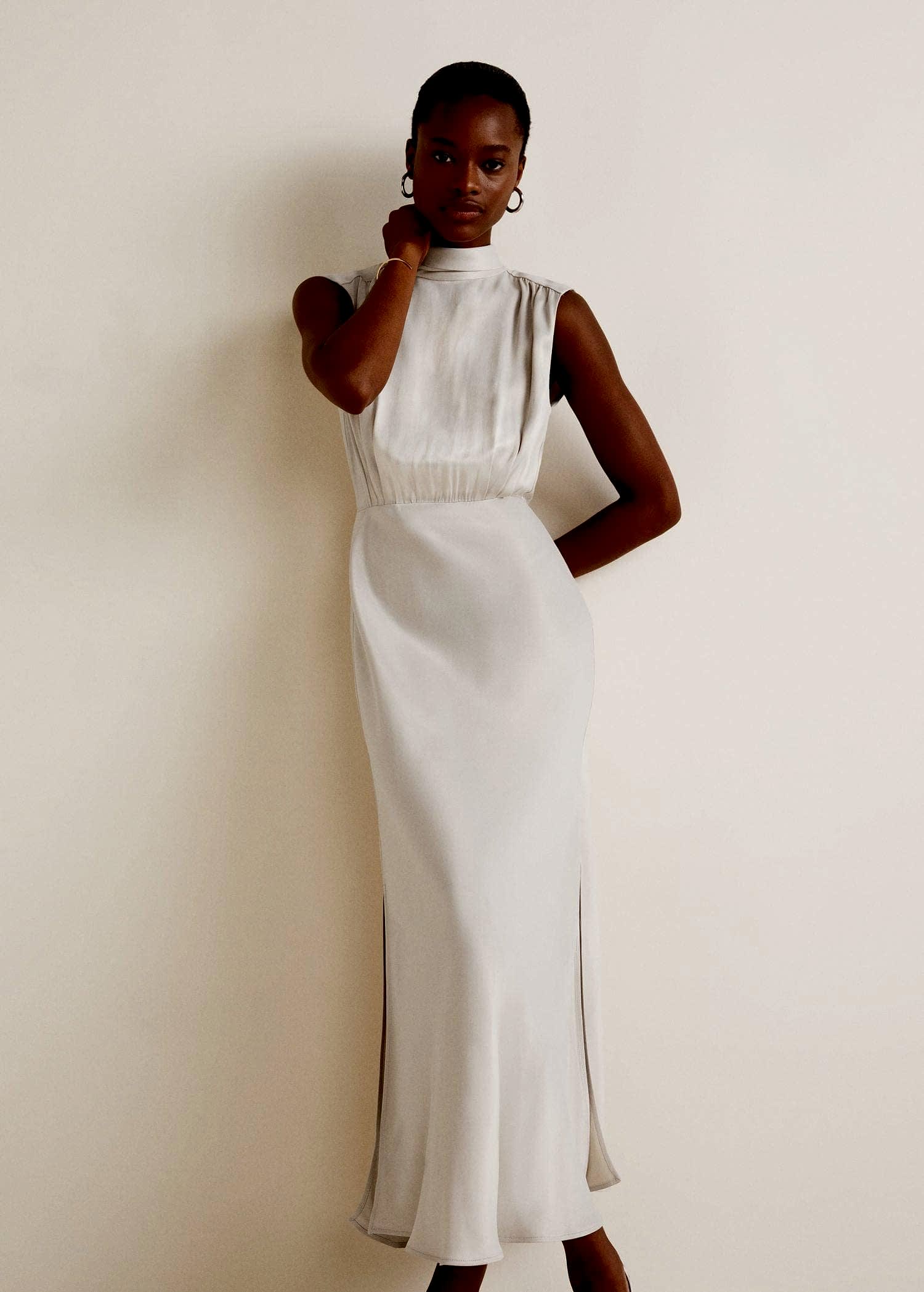 black woman with short hair wearing a high neck ivory satin gown