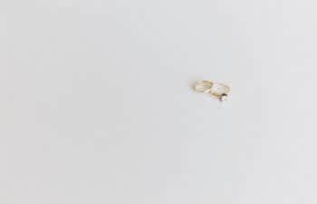 two gold wedding rings on a white surfce
