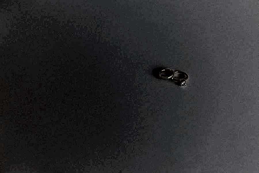 two gold wedding rings on a white surfce