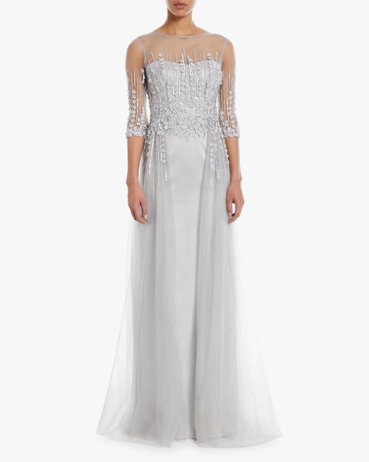 Woman in silver gown standing in white room