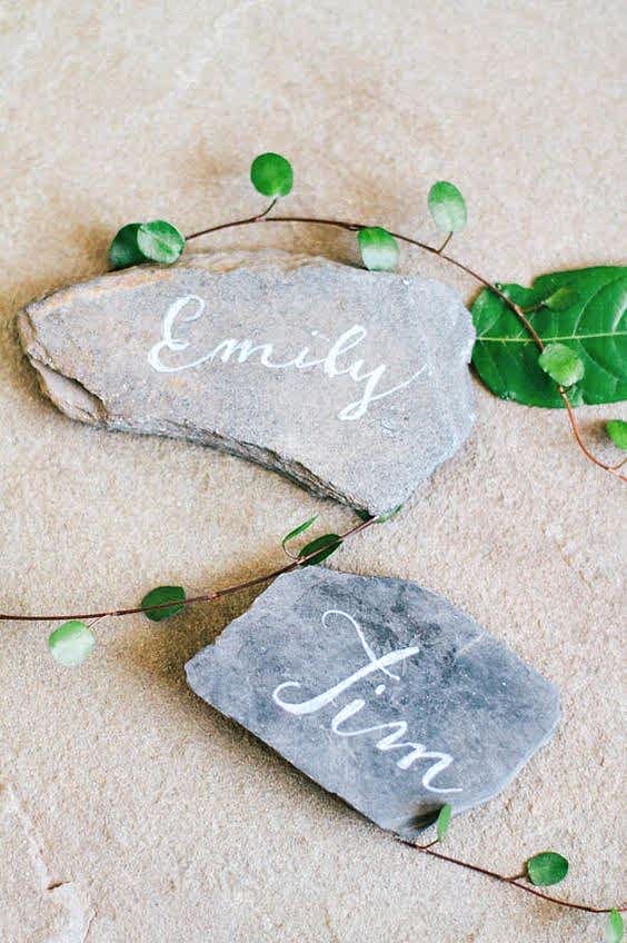 pieces of slate in grey winter wedding colors with names calligraphied on them in white