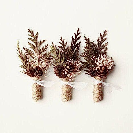 Three boutonnières in winter wedding colors: fir and pinecones