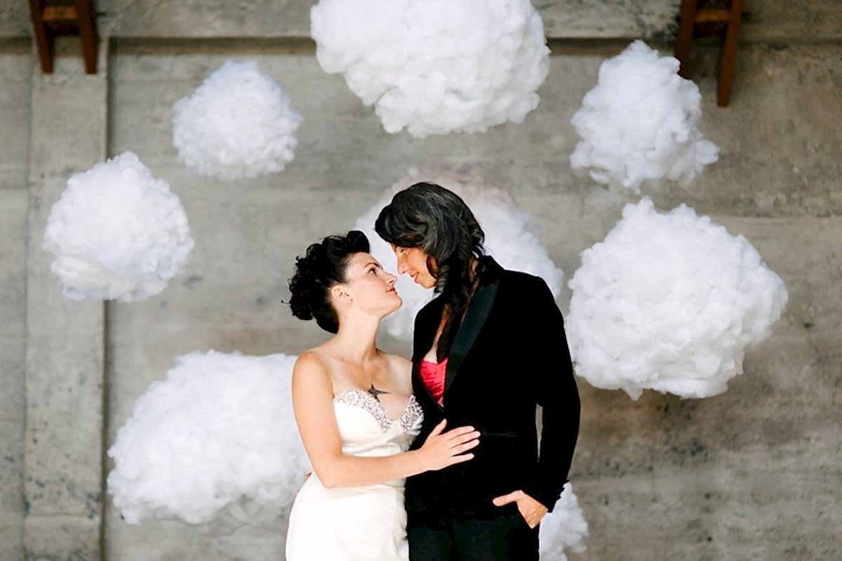 Wedding ideas for a DIY backdrop—two women in front of clouds suspended with invisible wire