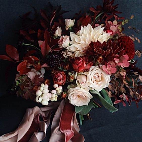 Bouquet in winter wedding colors: red, burgundy, white, and cream on a navy background, with velvet ribbons