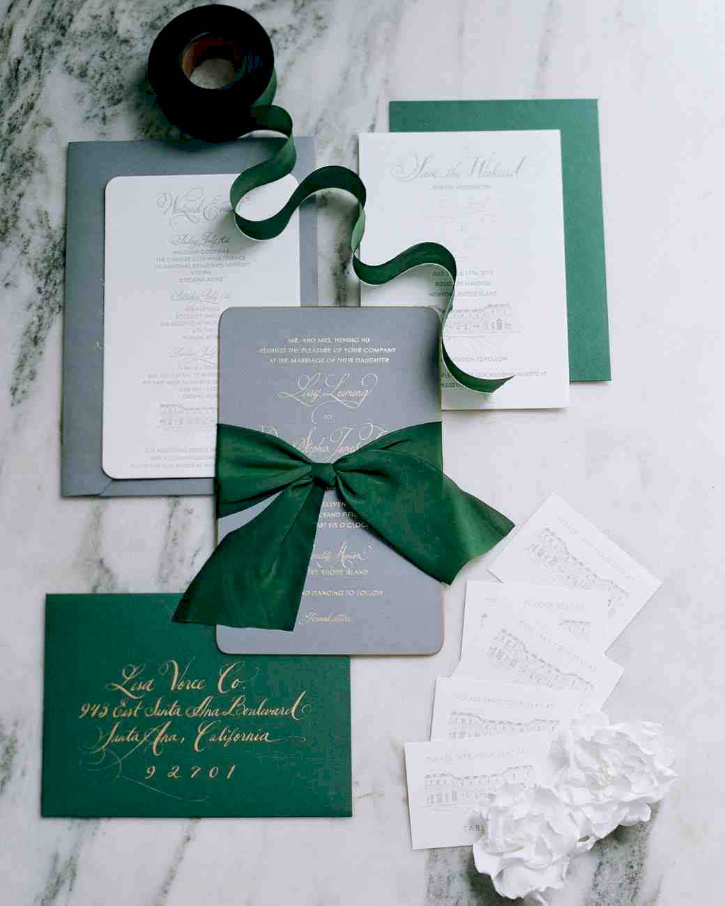 Invitation suite with winter wedding colors green details on marble table