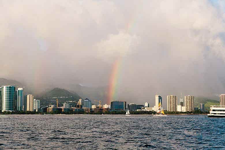 A double rainbow across the water above the Honolulu skyline at a destination wedding