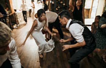 two people on the dance floor at their wedding reception getting down to the best wedding songs of 2019