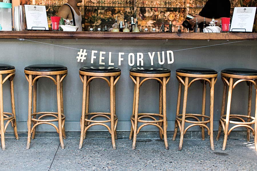 Barstools in front of a bar with a sign hanging above that reads "#FELFORYUD"