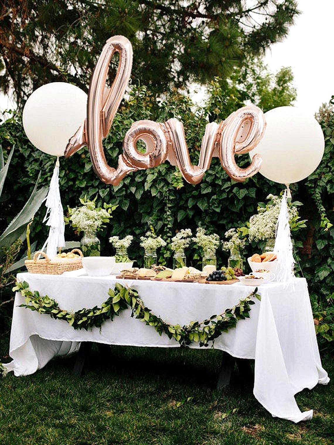 Balloon shaped like the word Love over a festive table as an engagement party idea