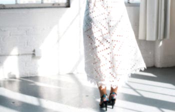 the back of a woman wearing a short wedding dress and heels from the waist down