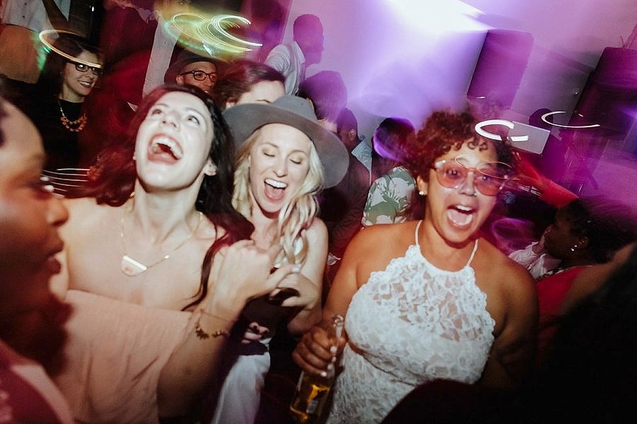 Two women dancing happily at their wedding reception